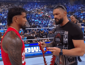 Roman Reigns Passing Garland To Jey Uso GIF