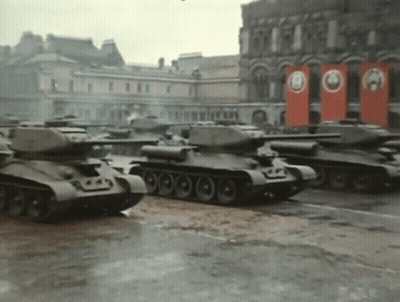 Row Of Black And White Tanks Driving In Snow GIF