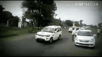 Row Of Cars Driving Down Road In Black And White Photo GIF