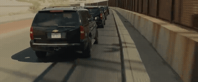 Row Of Cars On Highway Near Fence GIF