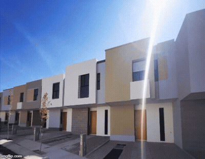 Row Of Houses With Sun Shining Through GIF