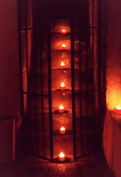 Row Of Lit Candles In A Cage GIF