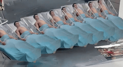 Row Of Men In Hospital Beds With Woman Picture On Floor GIF