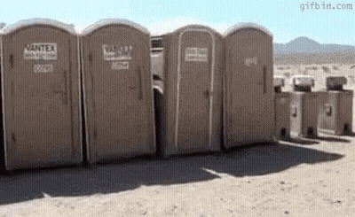 Row Of Portable Toilets In Desert GIF