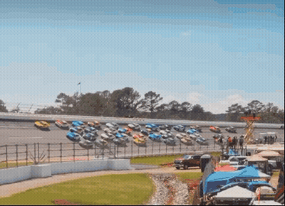 Row Of Race Cars Lined Up On Track GIF