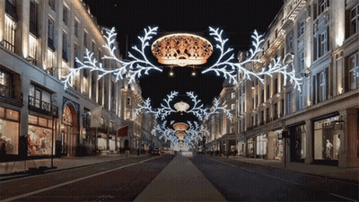 Row Of Shops Lit Up At Night With Crown Hanging GIF