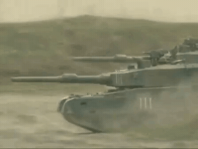 Row Of Tanks Driving Down Dirt Road GIF