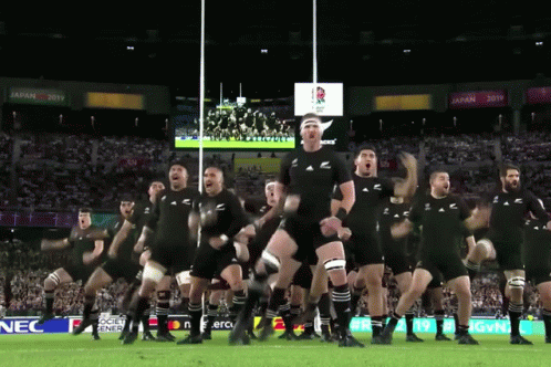 Rugby Players Performing Haka With Nec Sign GIF