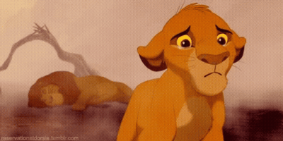 Sad Lion Cub Standing Next To Sleeping Lion GIF