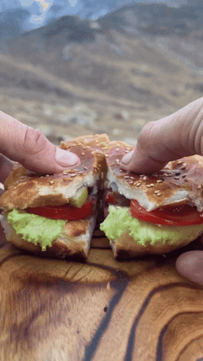 Sandwich With Lettuce Tomatoes And Sesame Seeds Cut In Half GIF