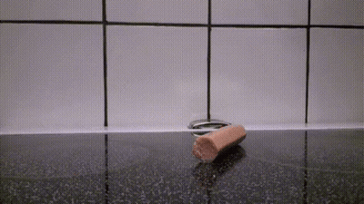 Salchicha sobre encimera negra GIF