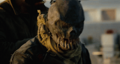 Scarecrow With Scarf Held By Man In Brown Jacket GIF