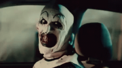 Scary Clown Sitting In Back Seat Of Car With Mouth Open GIF