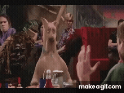 Scooby Doo Is Sitting At A Table In A Diner With A Group Of People . GIF