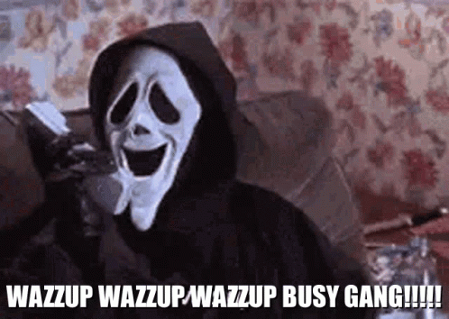 Scream Is Sitting On A Couch Talking On A Cell Phone While Wearing A Hooded Jacket . GIF