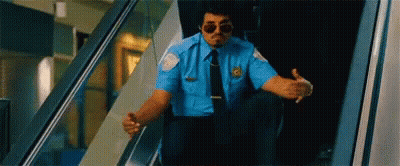 Security Guard Sitting On Escalator Wearing Sunglasses GIF