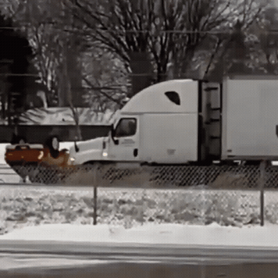 Semi Truck Driving On Snow Covered Highway GIF