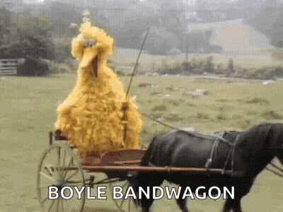 Sesame Street Big Bird Is Riding A Horse Drawn Carriage In A Field . GIF