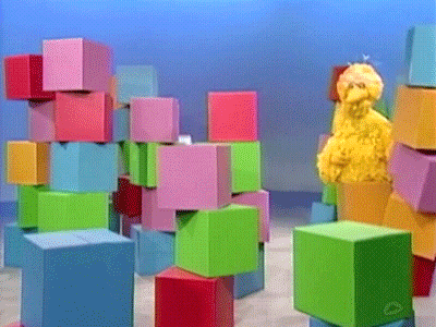 Sesame Street Big Bird Standing In Front Of A Stack Of Blocks GIF