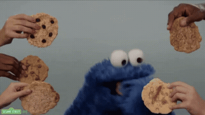 Sesame Street Cookie Monster Being Surrounded By People Holding Cookies GIF