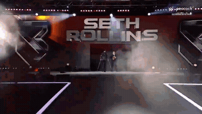 Seth Rollins Is Walking Down The Aisle Of A Stage GIF