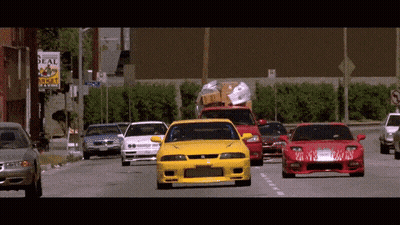 Several Cars Are Driving Down A Street In Front Of A Real Estate Sign GIF