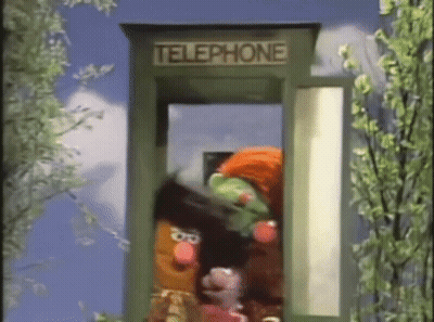 Several Sesame Street Characters Are In A Telephone Booth . GIF