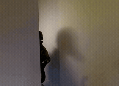 Shadow Of Person In Helmet And Gas Mask GIF