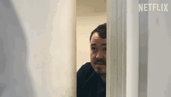 Shane Gillis Hiding Behind Door GIF