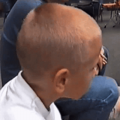 Shaved Head Boy Next To Woman In Chair GIF