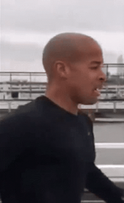 Shaved Head Man Walking In Black Shirt GIF