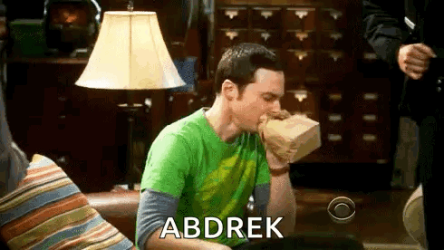 Sheldon Cooper From The Big Bang Theory Is Sitting On A Couch Eating A Bag Of Food . GIF