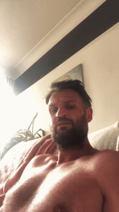 Shirtless Bearded Man Laying On Couch GIF
