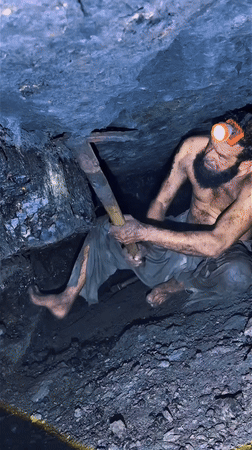Shirtless Bearded Man Using Pickaxe In Cave GIF