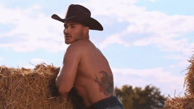 Shirtless Cowboy Leaning On Hay Bale GIF