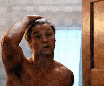 Shirtless Man Adjusting Hair In Mirror With Ocean GIF