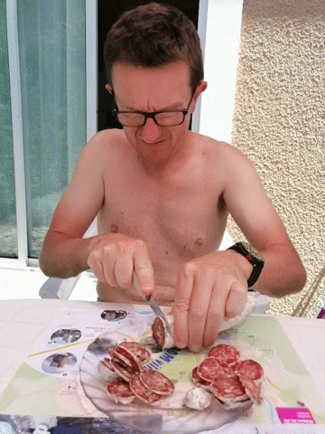 Shirtless Man Cutting Meat GIF