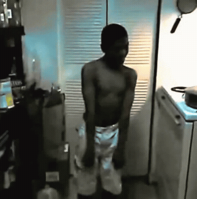 Shirtless Man Dancing In Kitchen With Pot On Stove GIF