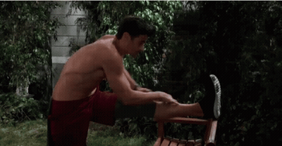 Shirtless Man Doing Leg Exercises on Chair Outside