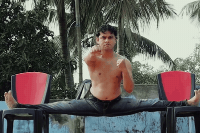 Shirtless Man Doing Split On Chair GIF