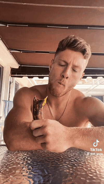 Shirtless Man Eating Banana At Table GIF