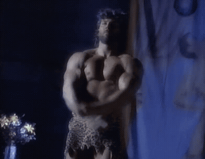 Shirtless Man Flexing Muscles In Dark Room GIF