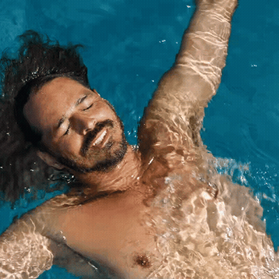 Shirtless Man Floating In Pool GIF