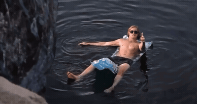 Shirtless Man Floating On Raft Giving Thumbs Up GIF
