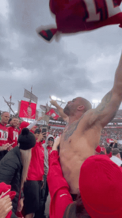 Shirtless Man Held Up By Fans GIF