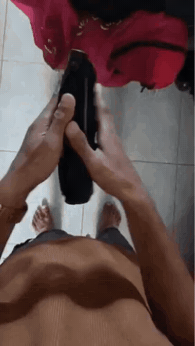 Shirtless Man Holding Black Object On Tiled Floor GIF