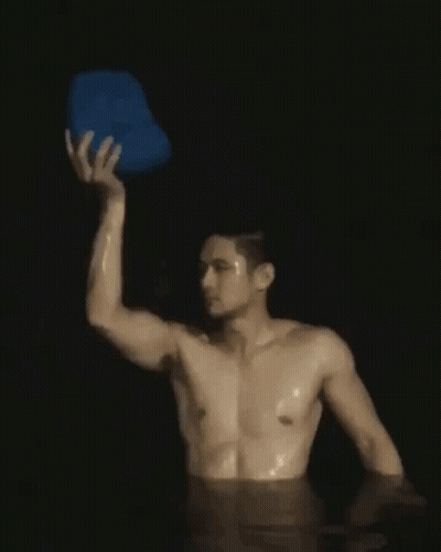 Shirtless Man Holding Blue Bucket Over Head In Water GIF