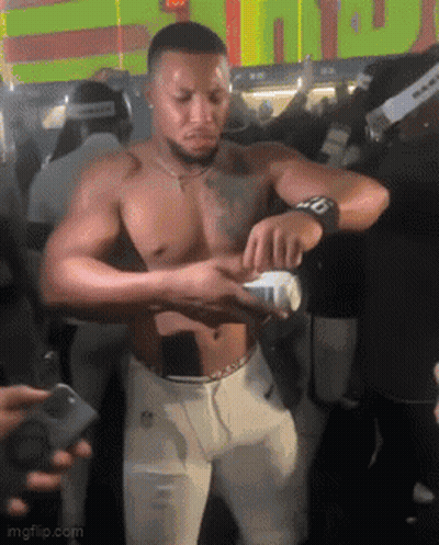 Shirtless Man Holding Bottle In Front Of Crowd GIF