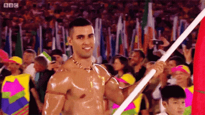 Shirtless Man Holding Flag At Parade GIF