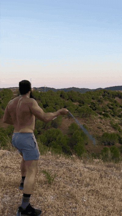 Shirtless Man Holding Hose In Field GIF